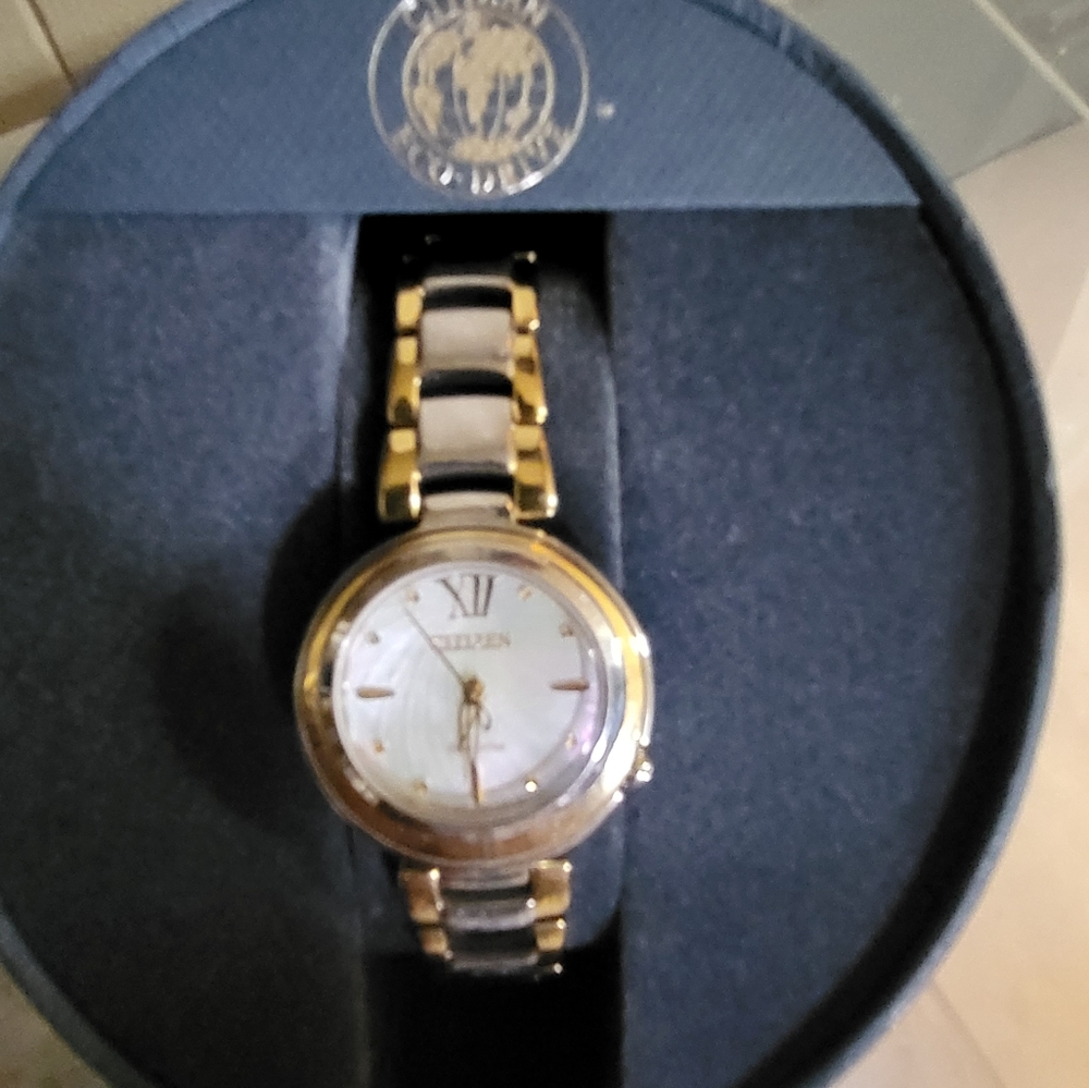 Citizens women's Eco-Drive watch with a pearl face and gold trim and a gold hand